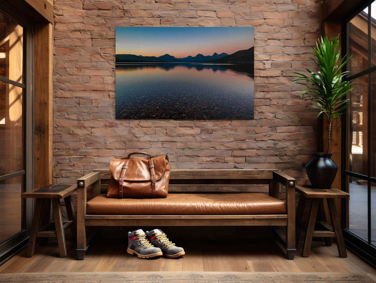 Glacier National Park Print showing calm blue Lake McDonald, rocky shallows, mountain silhouettes, and a warm sunset sky