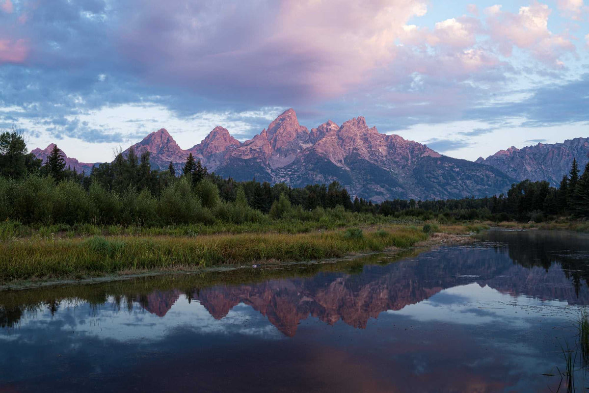 Grand Teton Sunrise Print featuring rugged mountain peaks in pink sunrise light reflected in a calm river
