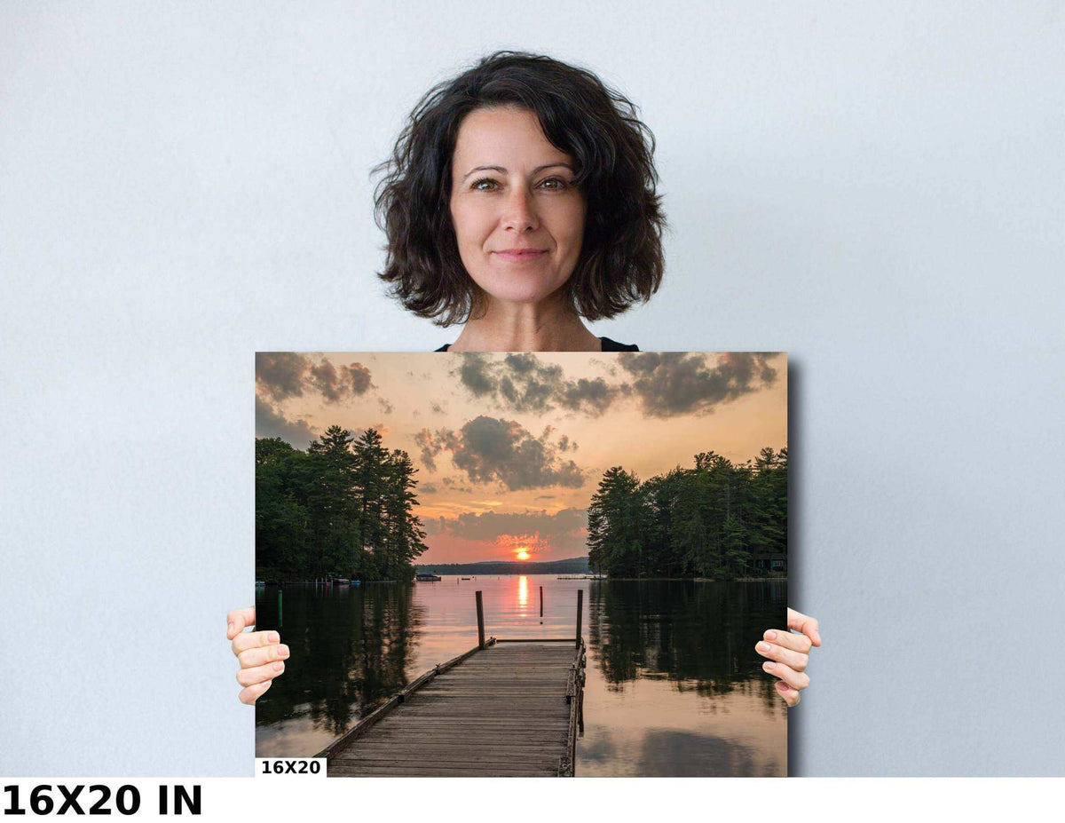 Great East Lake Dock Sunset Print shows a wooden dock framed by dark trees beneath a warm, clouded sunset sky.