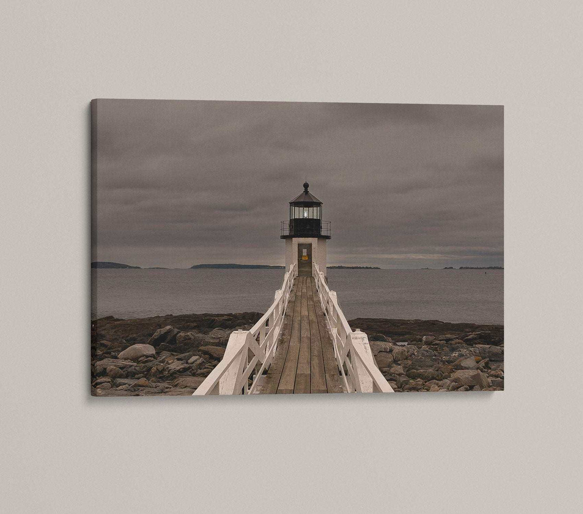 Marshall Point Lighthouse Print with a white lighthouse at the end of a wooden walkway, rocky shore and grey sky