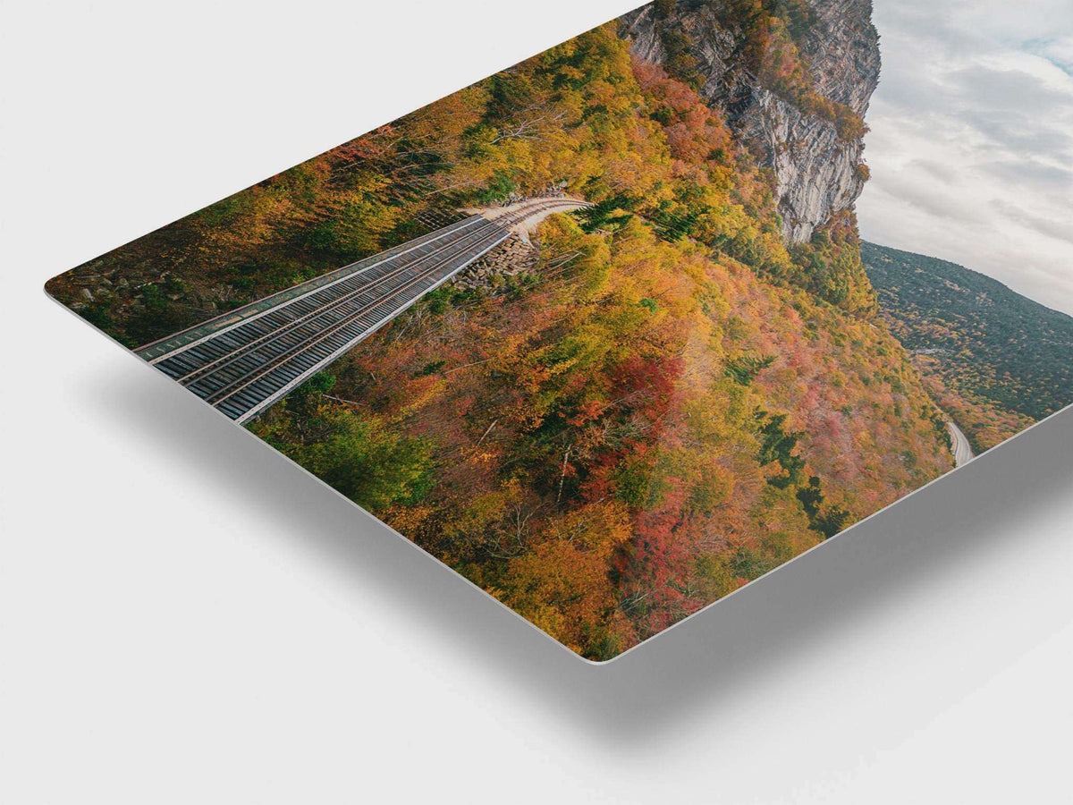 New Hampshire Fall Foliage Print showing autumn-colored mountain forest, railroad tracks, and a rocky cliff on a metal panel