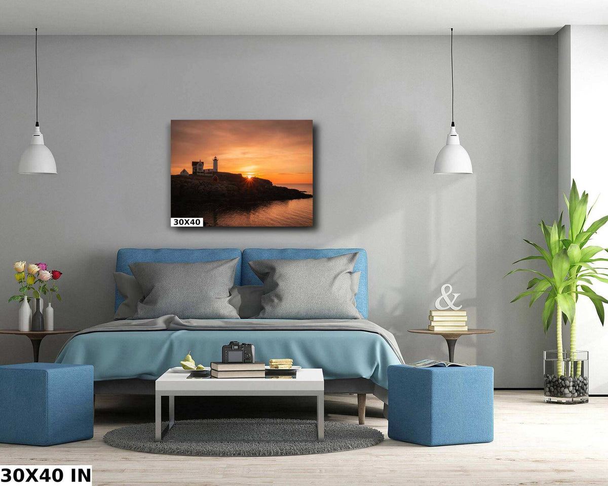 Nubble Lighthouse Print showing a dark coastal lighthouse silhouette against an orange sunrise over calm water