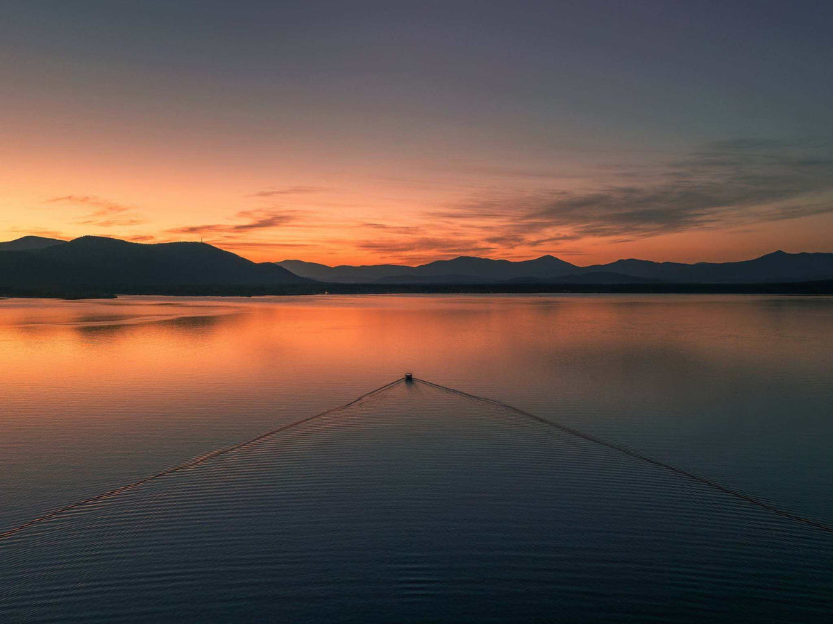 Ossipee Lake Wall Art landscape print showing calm blue water, dark mountain silhouettes, and a vivid orange sunset