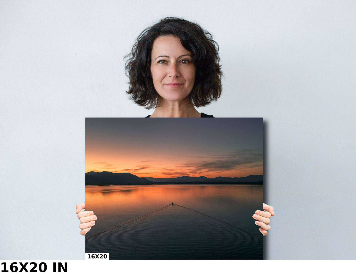 Ossipee Lake Wall Art print with orange sunset reflected on calm water beneath dark mountains, featuring a boat line