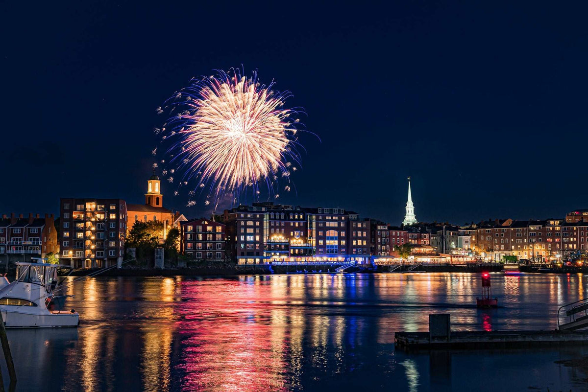 Portsmouth NH Fireworks Print showing bright gold and pink fireworks above the harbor, with waterfront buildings reflected on the water