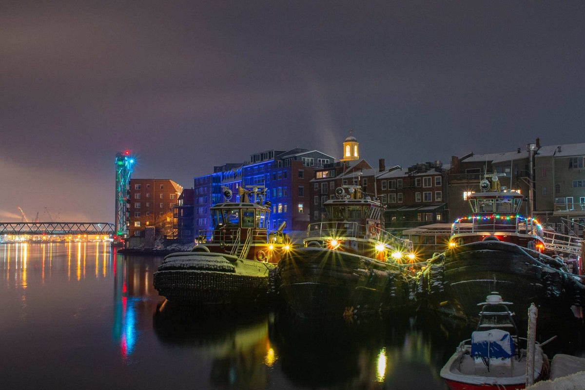Portsmouth NH Wall Art shows dark tugboats with snow-dusted decks, colorful harbor lights, and reflections on still water