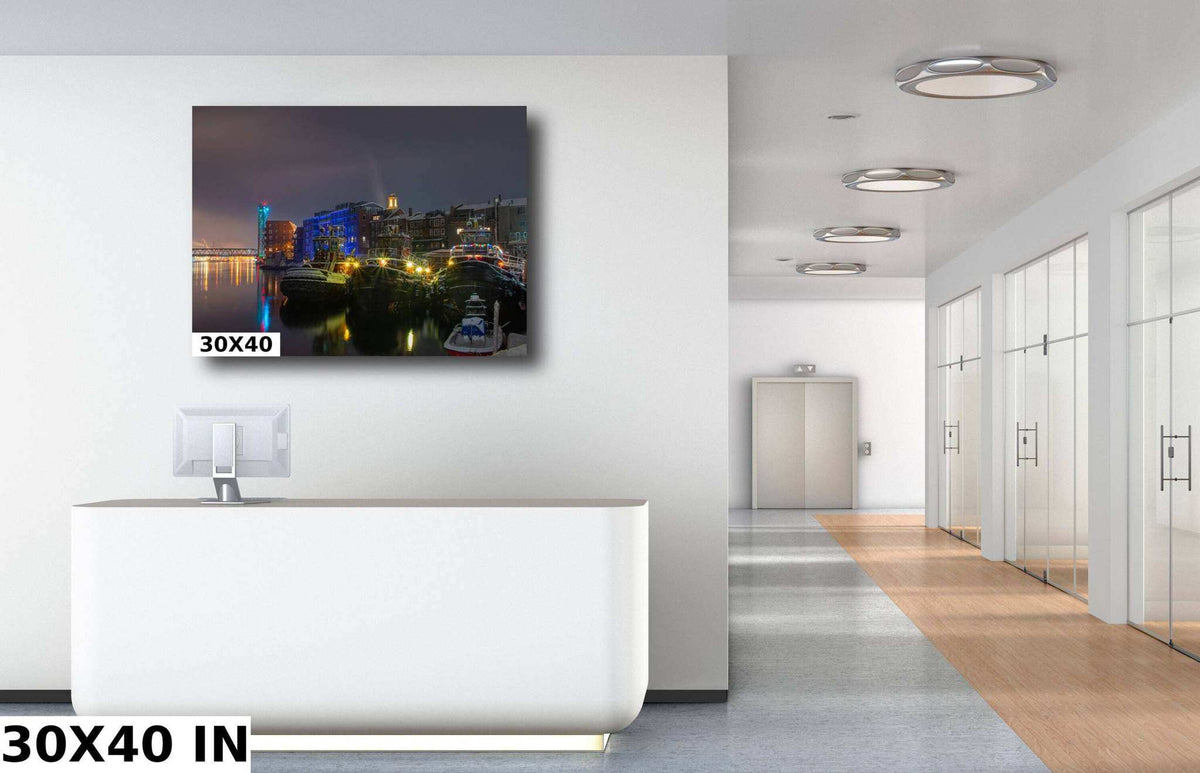 Portsmouth NH Wall Art shows a framed harbor photograph with tugboats, glowing city lights, and colorful nighttime reflections.
